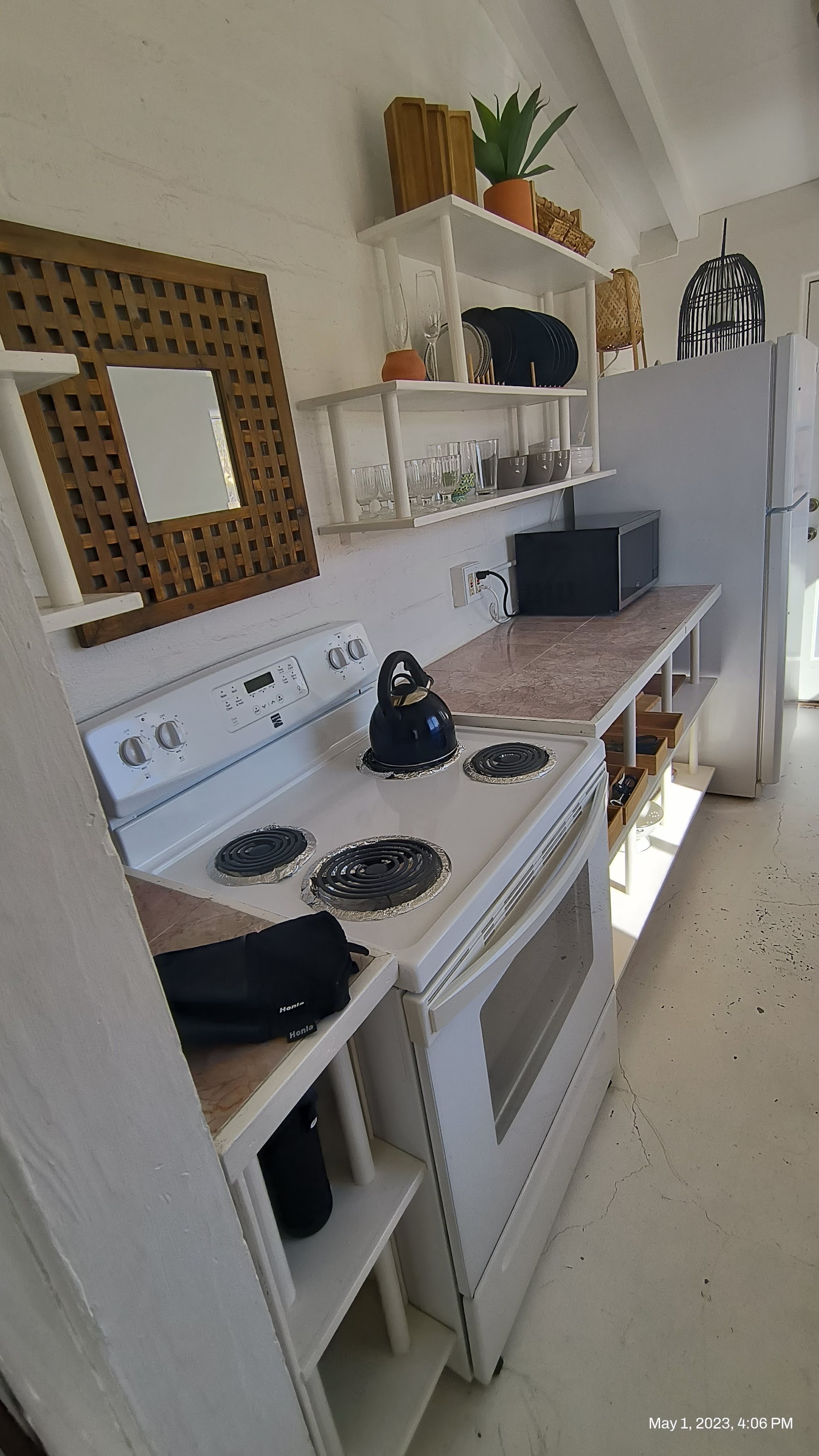 Small kitchen with white electric range, microwave, and refrigerator